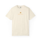 An off-white short-sleeve crewneck t-shirt with a small gold graphic and 'Beach Bum' text printed on the center chest, displayed against a solid white background.