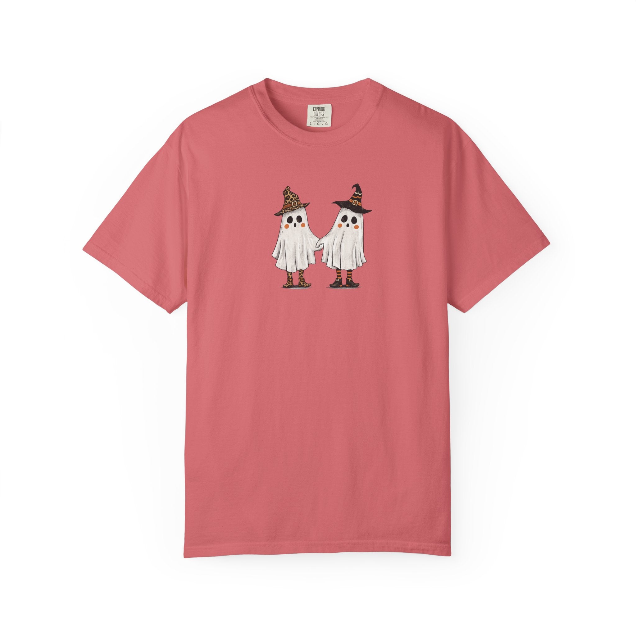 A dusty rose pink short-sleeve t-shirt with a graphic of two cute cartoon ghosts wearing witch hats on the chest, displayed flat against a solid white background.