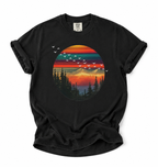 Black t-shirt with a colorful sunset and forest graphic on a white background