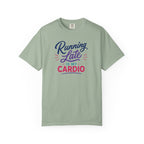 A sage green short-sleeve t-shirt with a colorful graphic on the chest that reads 'Running Late IS MY CARDIO' in purple, blue, and pink lettering, displayed on a clean white background.