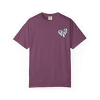 A short-sleeve crewneck t-shirt in a dusty plum purple color, featuring a small white heart graphic on the left chest with the word 'MAMA' written inside in a black-and-white pattern.