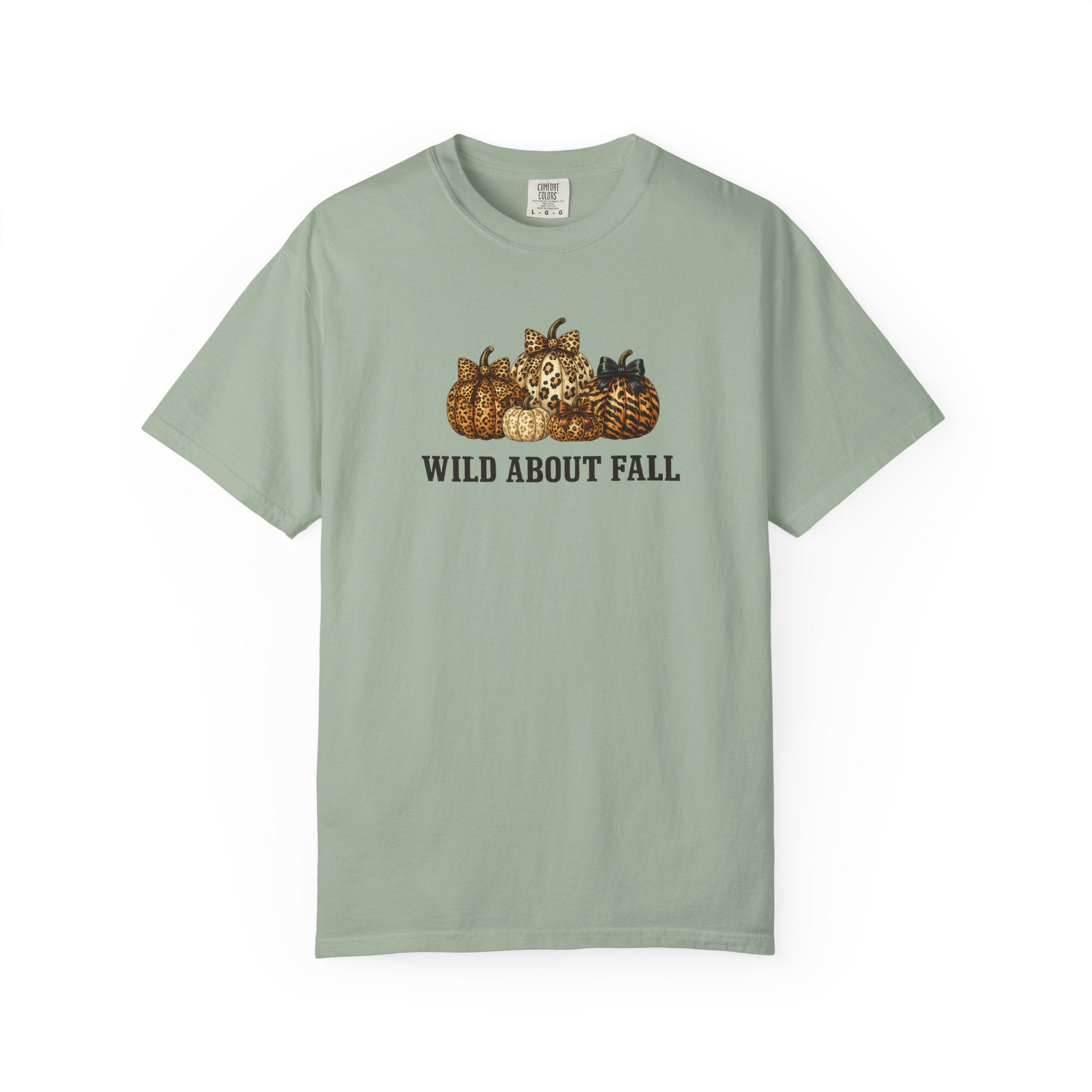 A sage green short-sleeve t-shirt with a graphic of pumpkins and the text 'WILD ABOUT FALL' printed on the chest, displayed against a plain white background.