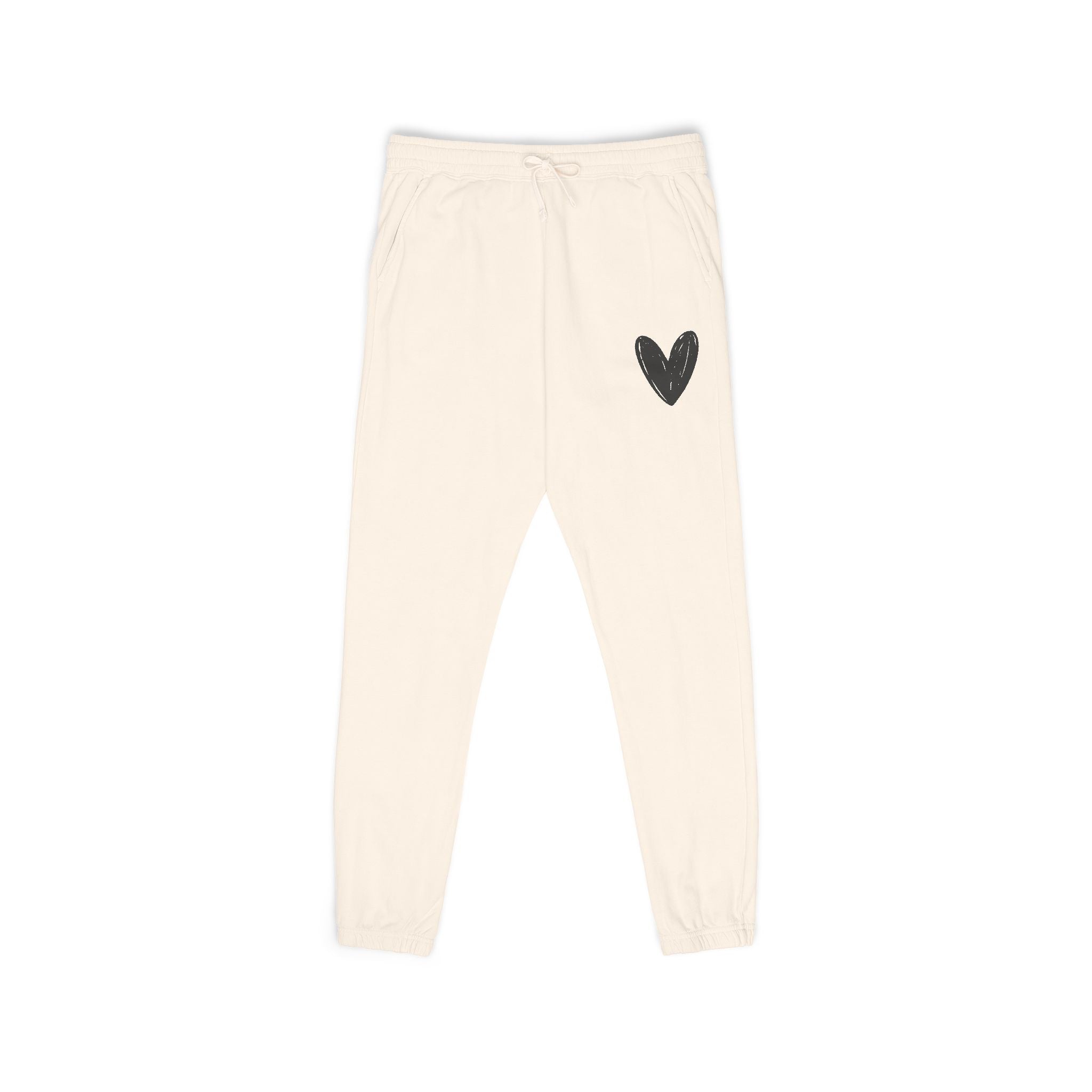 Off-white fleece jogger pants with a small black heart graphic on the upper left leg, featuring an elastic waistband with a drawstring and elastic cuffs.