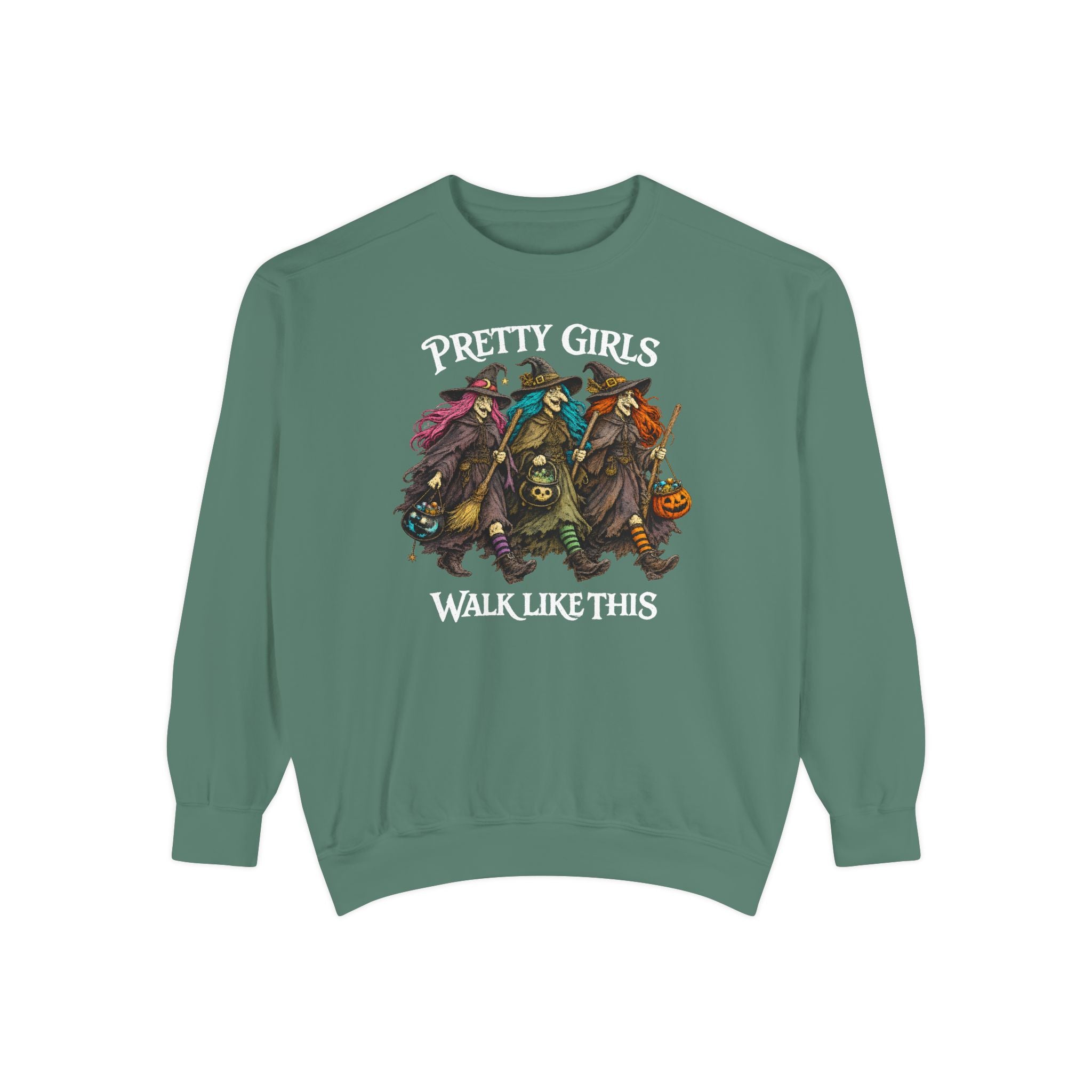 A sage green crewneck sweatshirt featuring a graphic of four witches riding on a pumpkin cart, with the text 'PRETTY GIRLS WALK LIKE THIS' printed in white around the illustration.