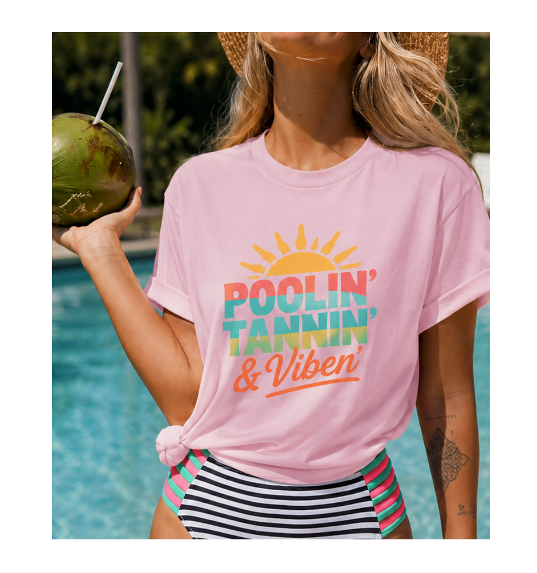 Woman wearing a pink t-shirt with 'Poolin' Tanning & Vibin' text by a pool.