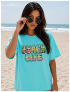 Woman wearing a blue 'Beach Life' t-shirt on a beach.