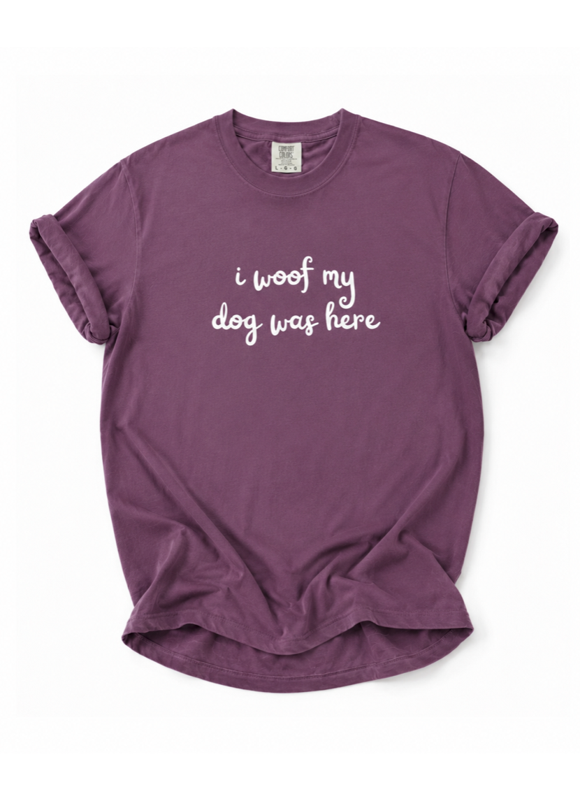 Purple t-shirt with 'i woof my dog was here' text on a white background