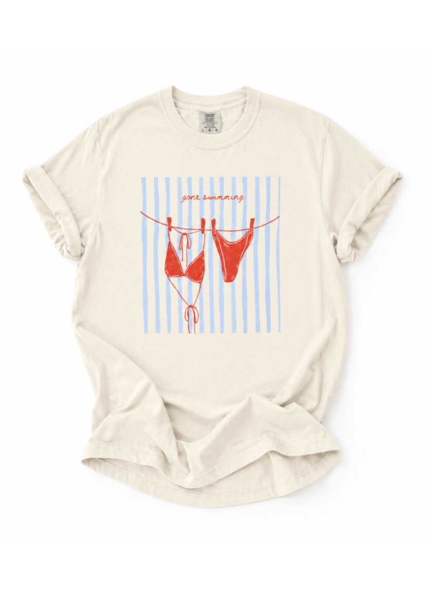 Beige t-shirt with red bikini graphic on a white background