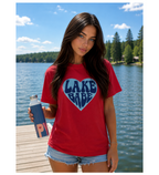 Woman wearing a red 'Lake Babe' t-shirt by a lake