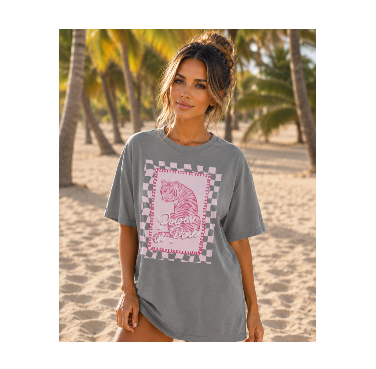 Woman wearing a gray t-shirt with a tiger graphic on a beach