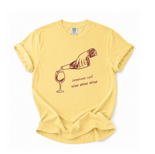 Yellow t-shirt with a graphic of a hand pouring wine into a glass and text on a white background