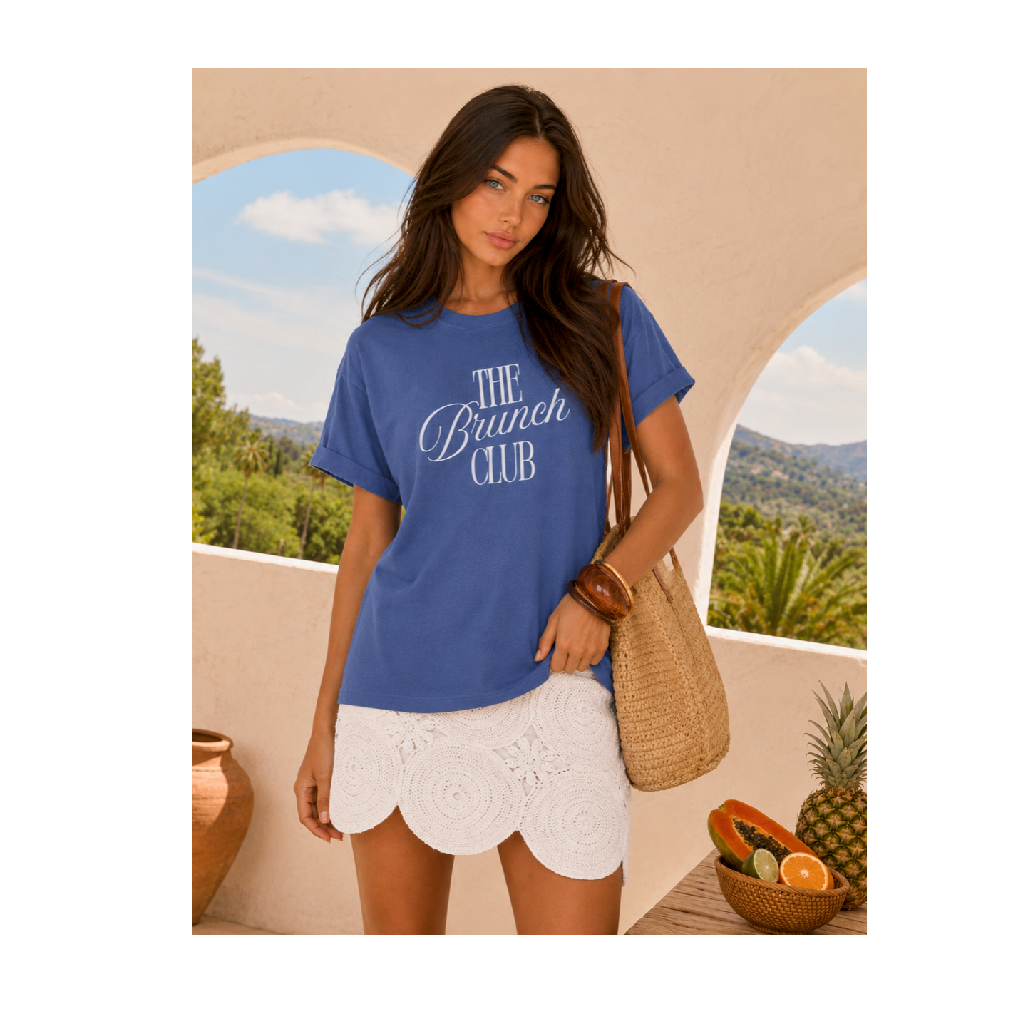 Woman wearing a blue 'The Brunch Club' t-shirt with a scenic background