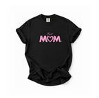 A black short-sleeve t-shirt with a pink graphic on the chest that reads 'Best MOM' with the letter 'O' stylized as a heart. The t-shirt is laid flat against a solid white background.