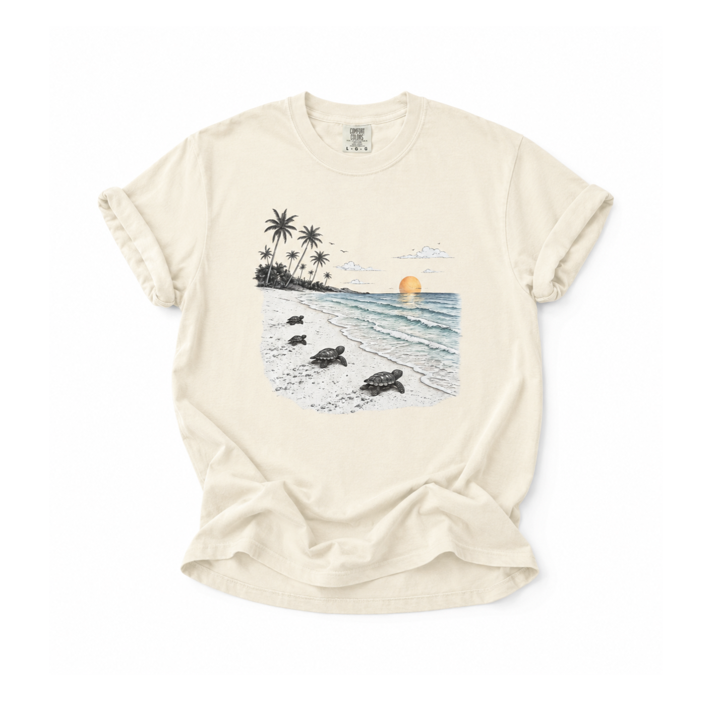 An off-white short-sleeve t-shirt with a graphic print of a tropical beach scene featuring sea turtles, palm trees, and a sunset, laid flat on a white background.