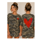 A woman modeling an oversized camouflage T-shirt dress from the front and back. The dress features a green, brown, and gray camo pattern with a small red heart on the front chest and a large red heart on the back.
